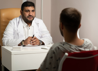 Picture of clinician and patient across a desk from each other