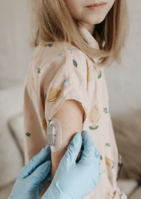 A child's arm showing an automatic glucometer