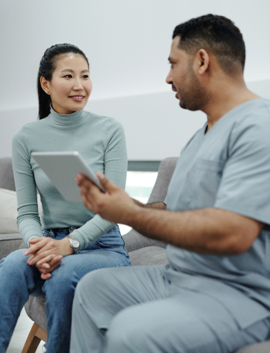 Clinician showing information on an electronic tablet to a patient